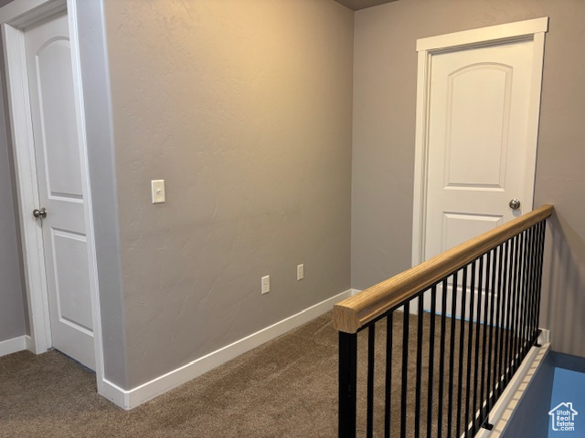 Corridor with carpet, baseboards, and an upstairs landing