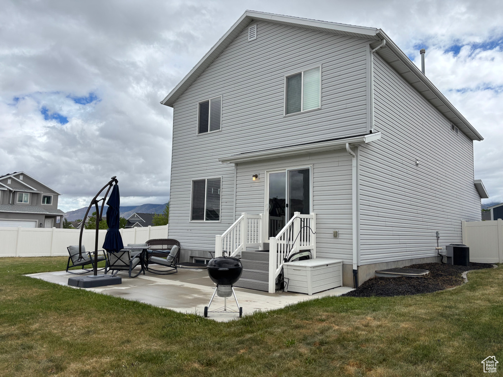 Back of house with a patio area and central air condition unit