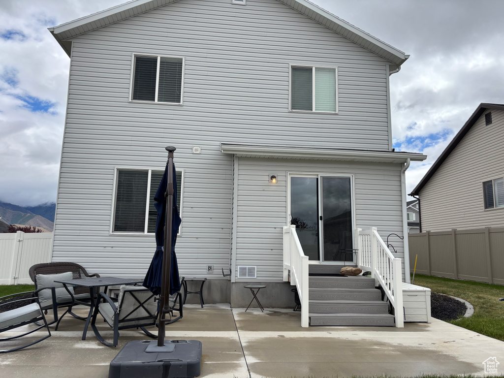 Back of property featuring fence and a patio
