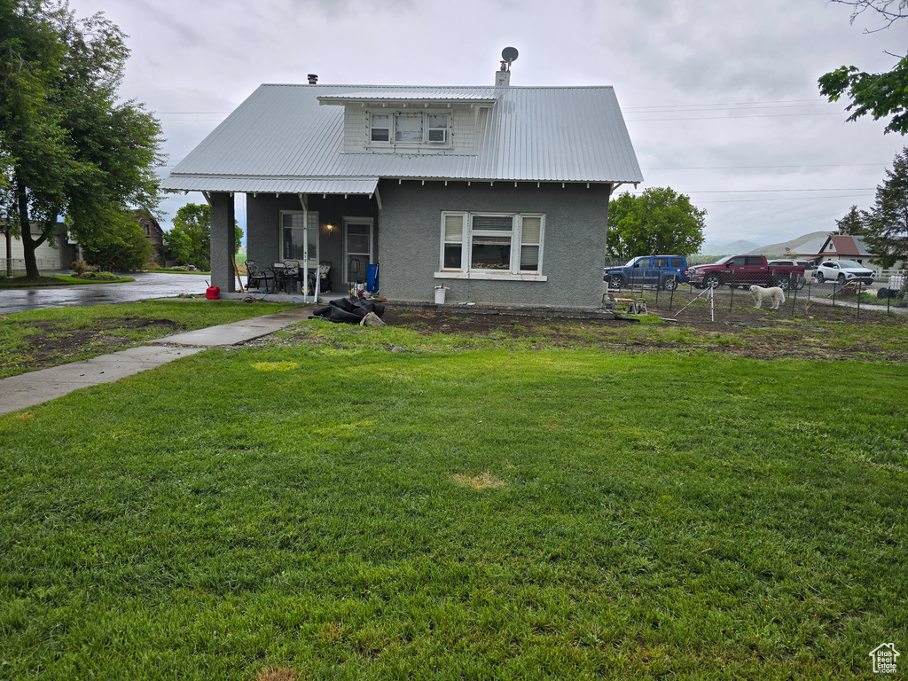 View of front of house featuring stucco siding and metal roof