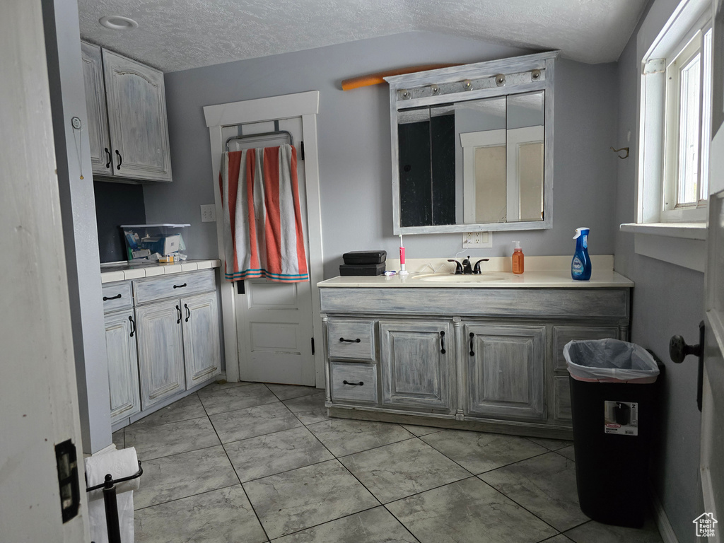 Bathroom with a textured ceiling and vanity