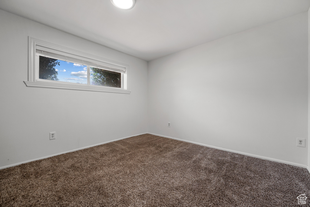 Spare room featuring carpet floors and baseboards
