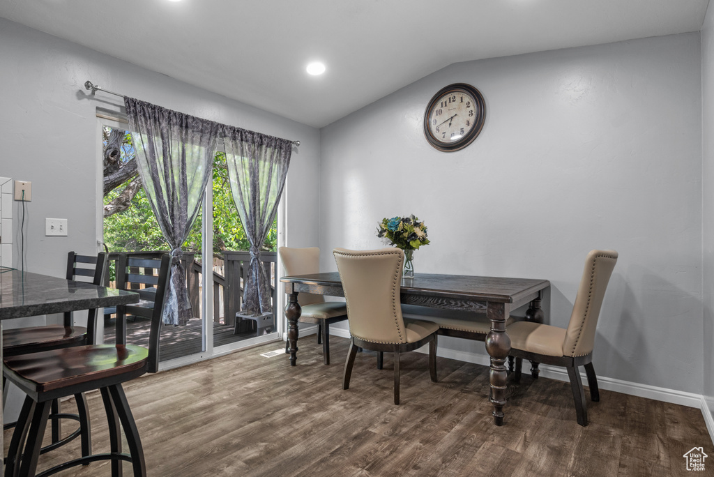 Dining area featuring vaulted ceiling, wood finished floors, and baseboards