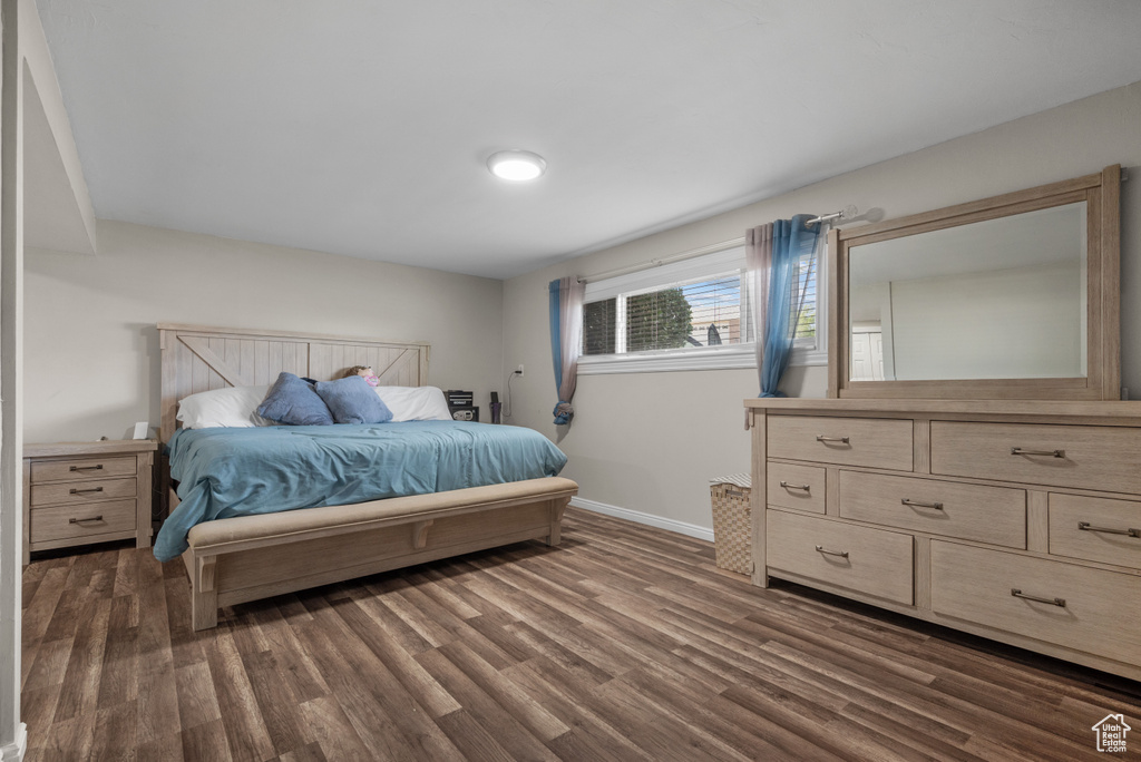 Bedroom featuring dark wood finished floors and baseboards