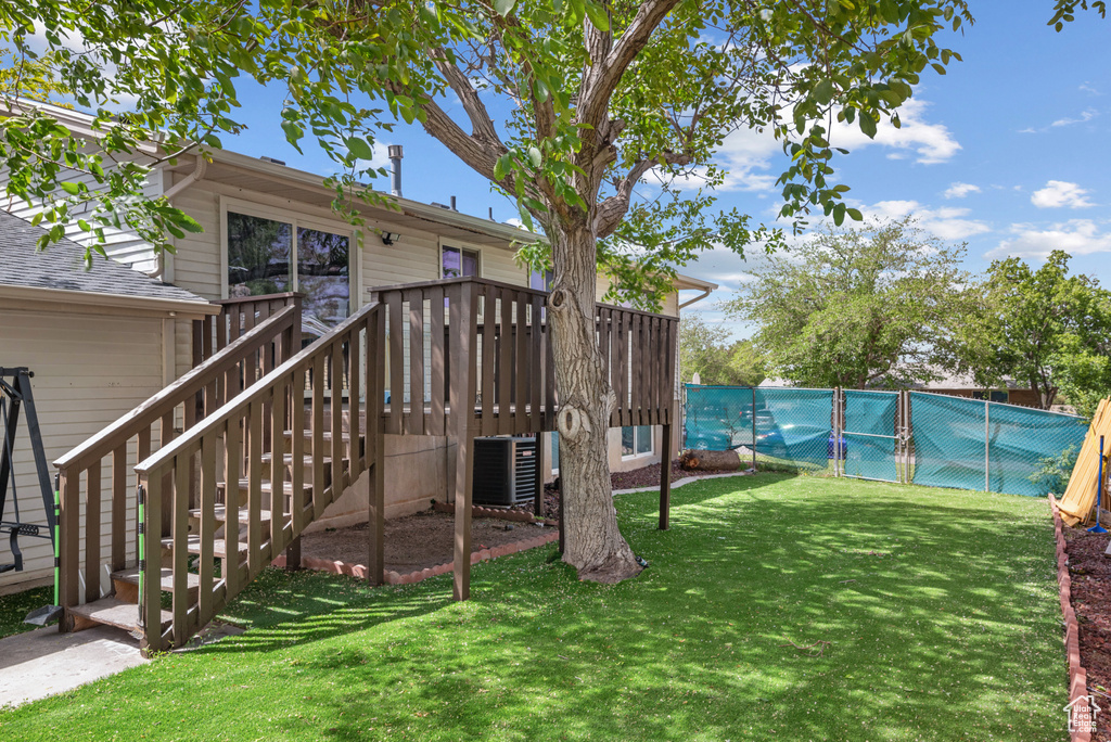 View of yard with a deck, stairs, and cooling unit