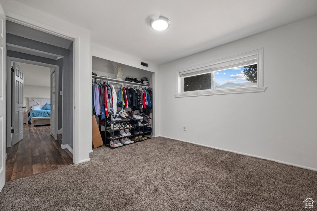 Bedroom featuring dark carpet, a closet, and baseboards