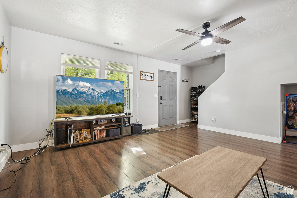 Living room featuring a ceiling fan, wood finished floors, and baseboards