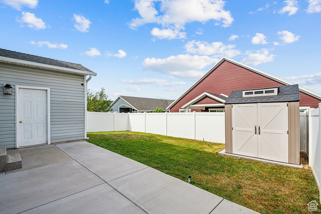 View of yard with a patio, a shed, and an outbuilding