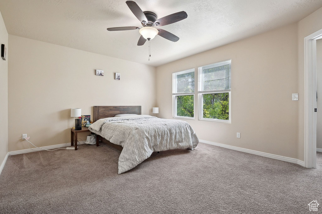 Carpeted bedroom with baseboards and ceiling fan