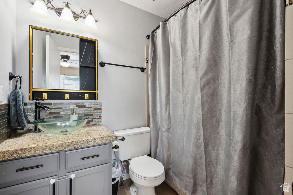 Bathroom with backsplash, toilet, and vanity
