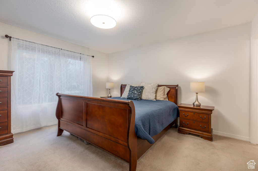 Bedroom featuring light colored carpet and baseboards