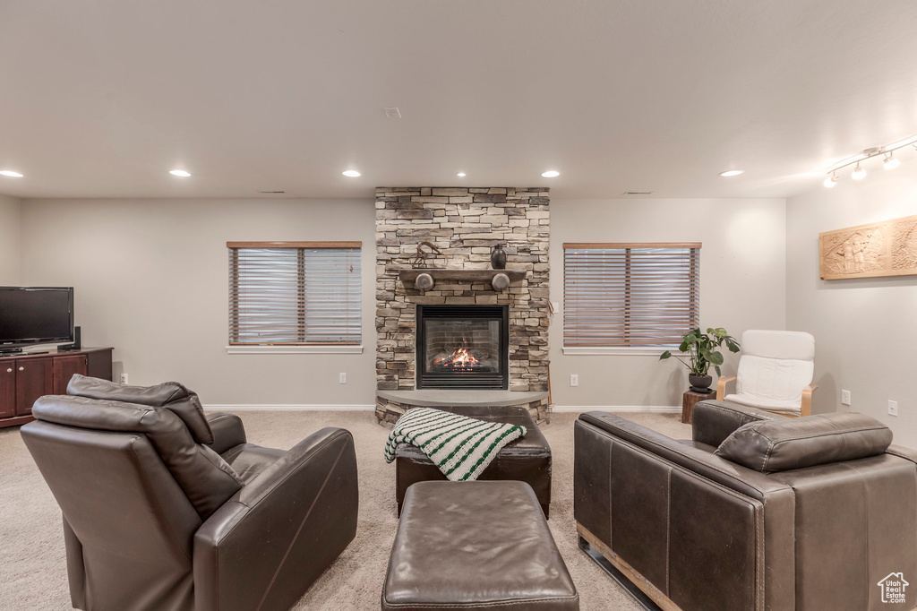 Living area featuring a fireplace, light carpet, recessed lighting, and baseboards