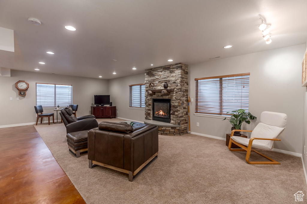 Living room featuring baseboards, recessed lighting, and a stone fireplace