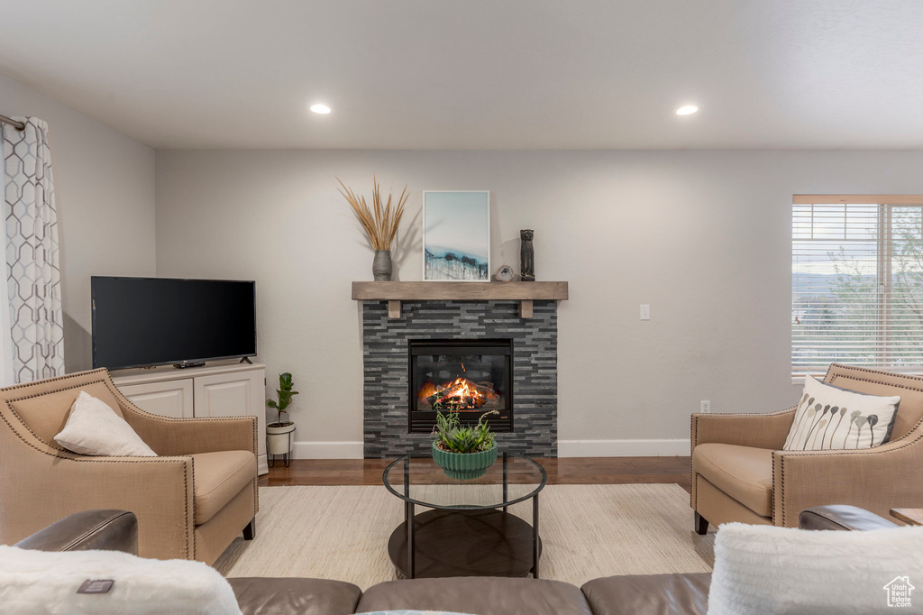 Living area with recessed lighting, baseboards, wood finished floors, and a fireplace