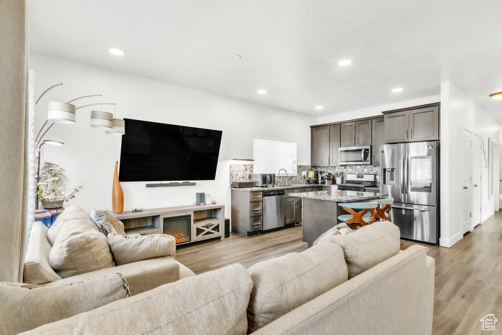 Living area featuring light wood finished floors and recessed lighting