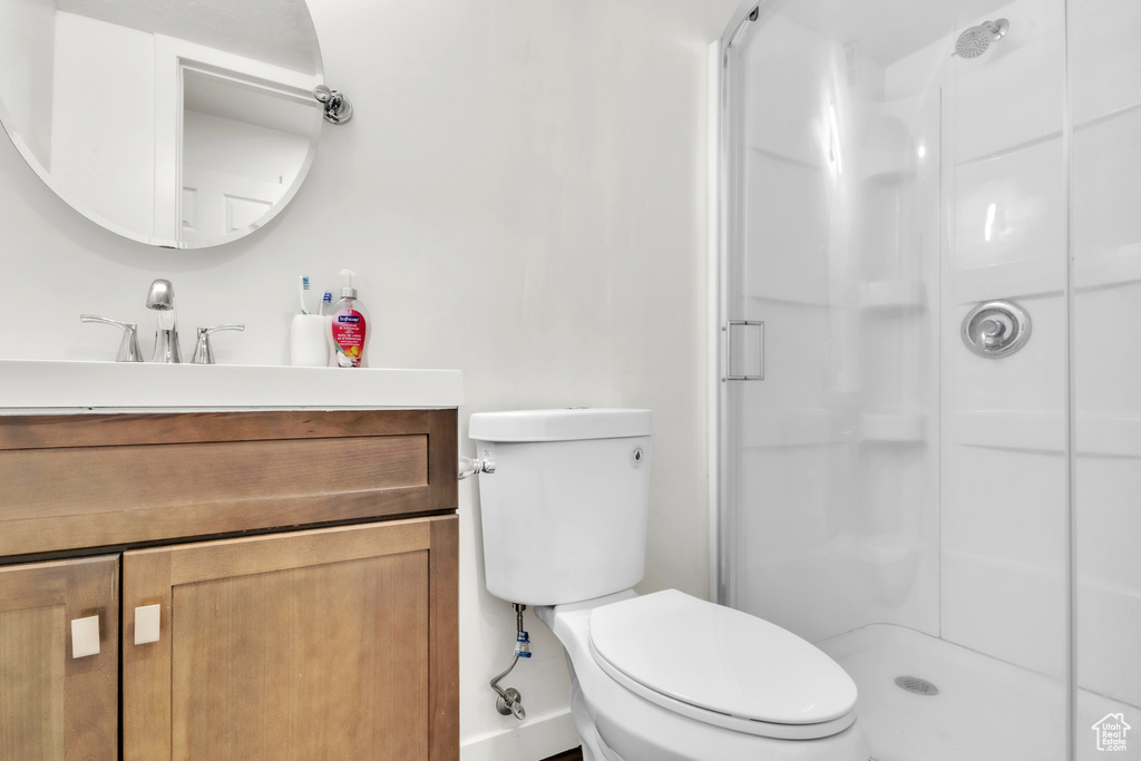 Bathroom with a shower stall, toilet, and vanity