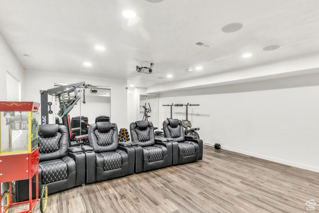 Home theater room featuring wood finished floors, recessed lighting, and baseboards