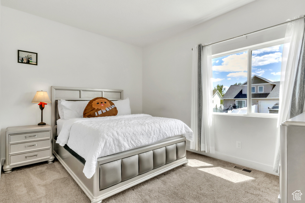 Bedroom featuring light carpet and baseboards