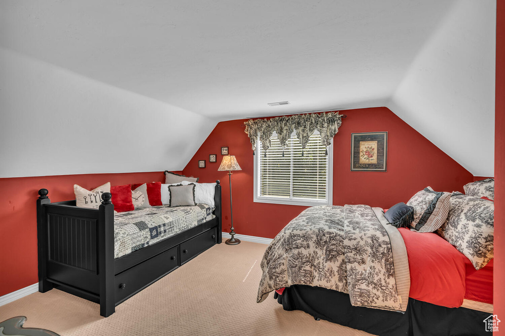 Bedroom with carpet flooring, vaulted ceiling, and baseboards