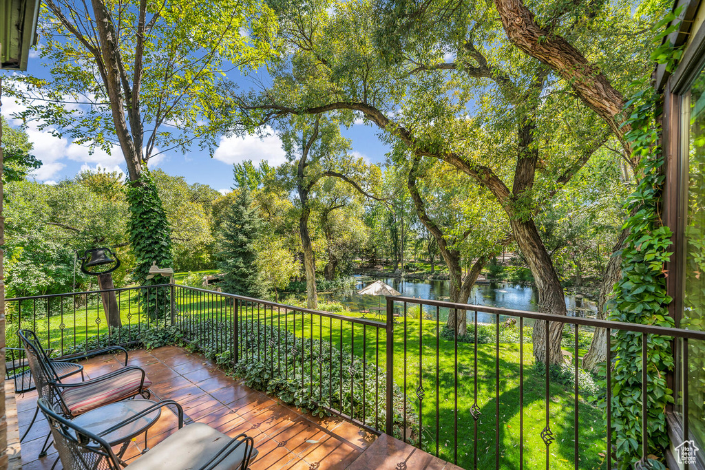 Deck featuring a water view and view of scattered trees