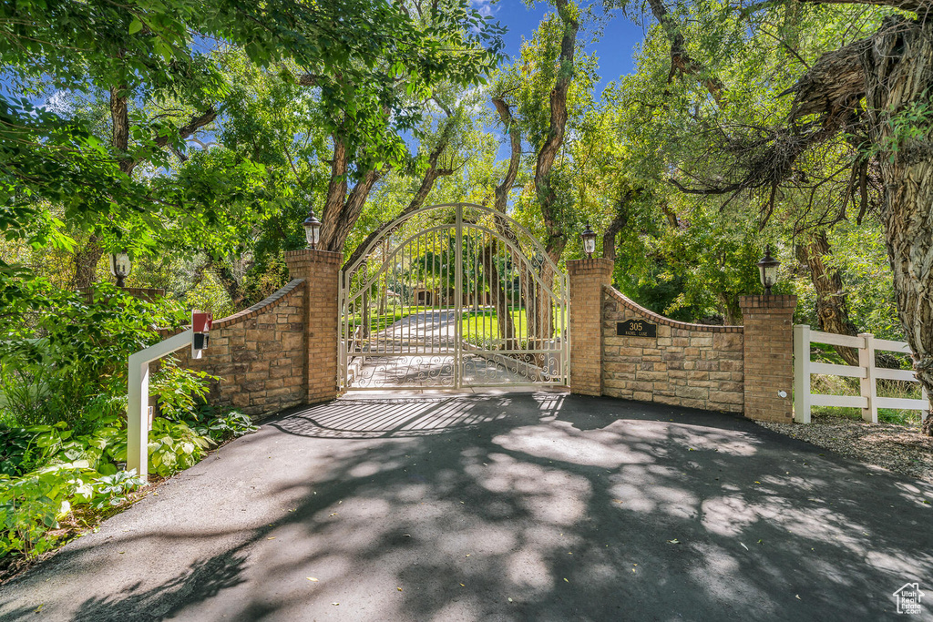 Gate with fence and view of wooded area
