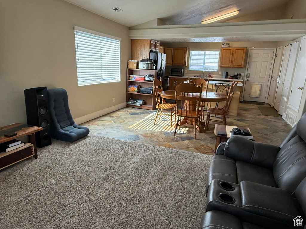 Dining space with baseboards and lofted ceiling