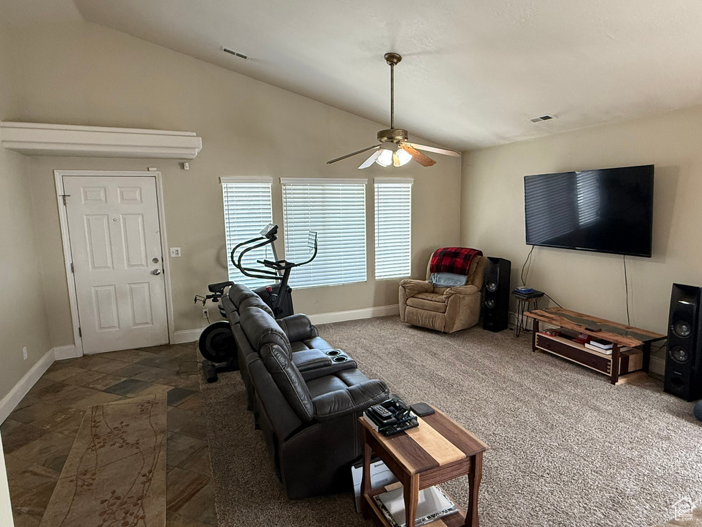Living room with vaulted ceiling, a ceiling fan, and baseboards