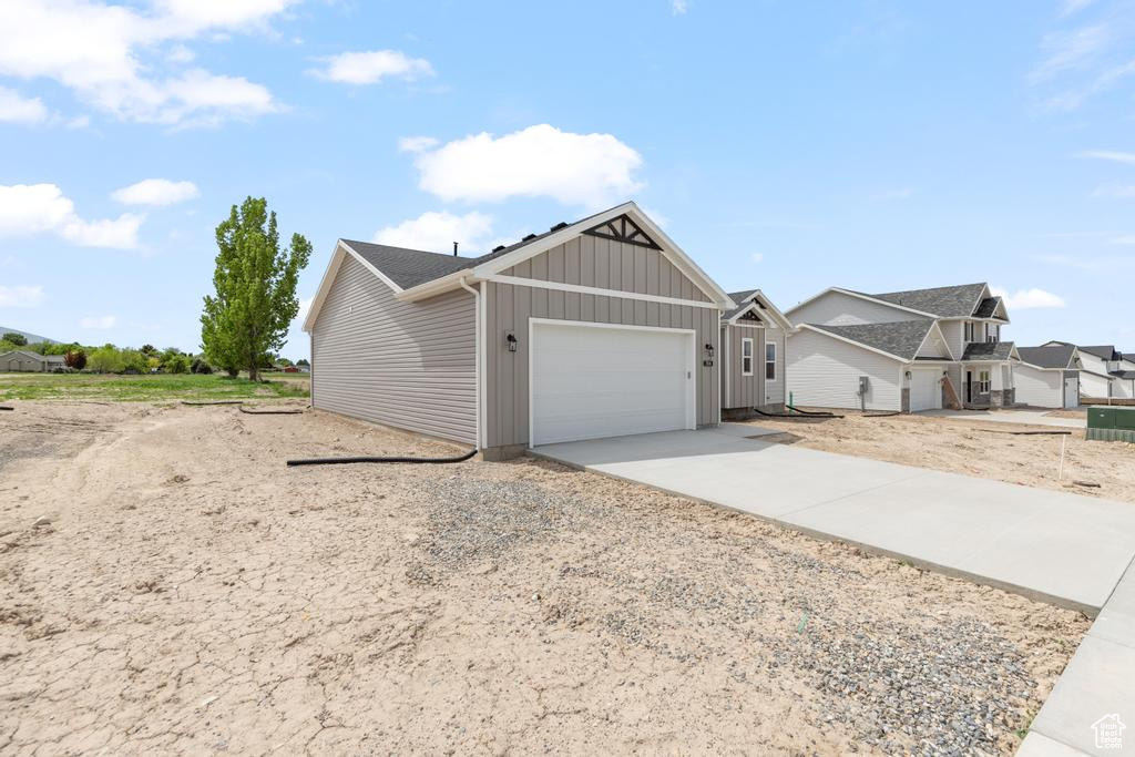 View of front of property featuring an attached garage, driveway, and board and batten siding
