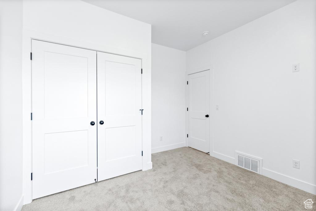 Unfurnished bedroom featuring carpet floors, baseboards, and a closet