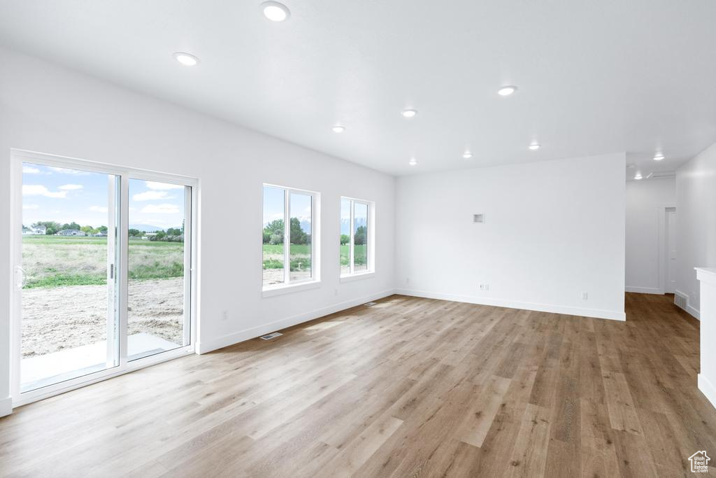 Unfurnished living room featuring light wood-style floors, recessed lighting, and baseboards