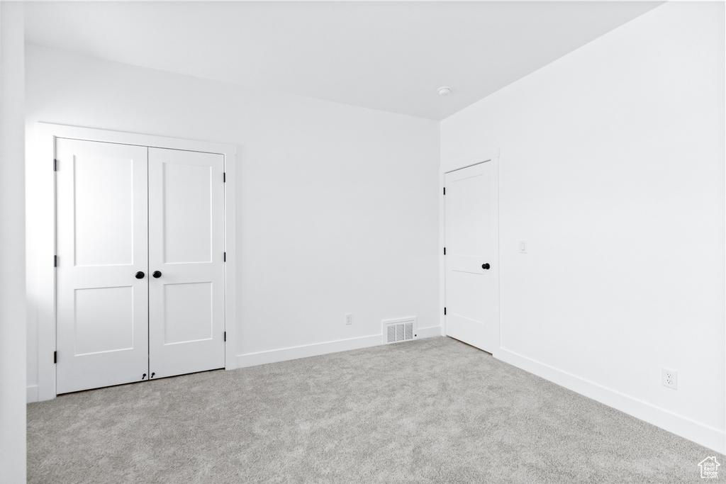 Unfurnished bedroom featuring carpet floors, baseboards, and a closet