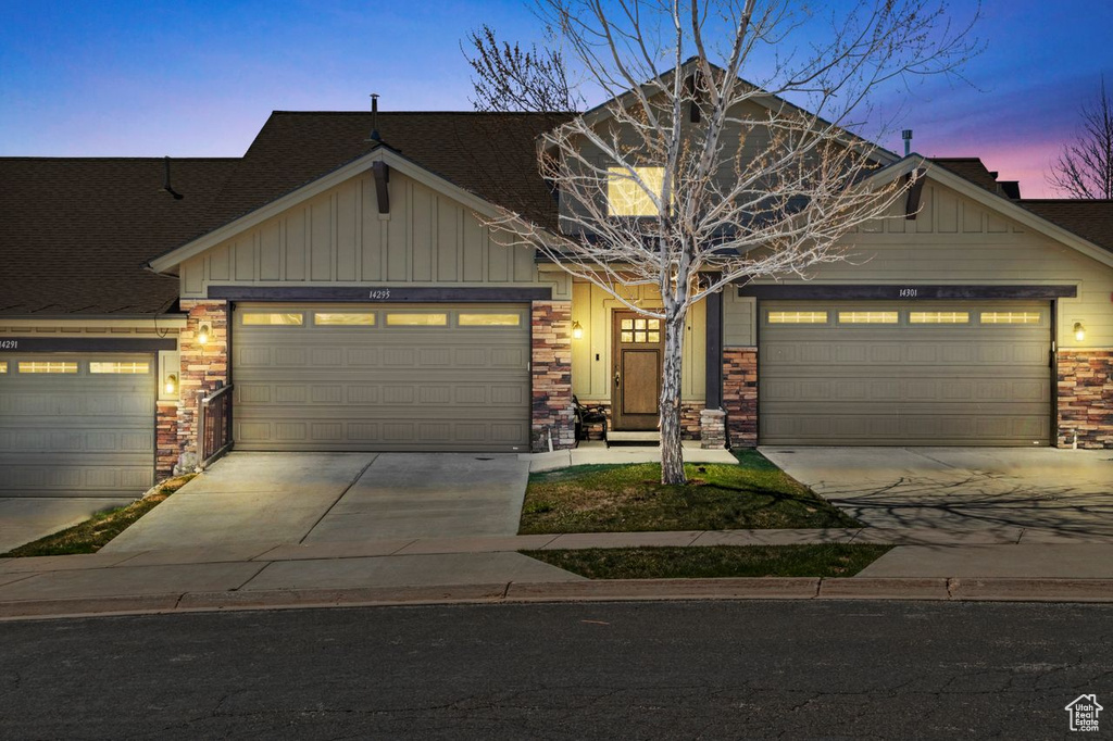 Craftsman house with board and batten siding, concrete driveway, and an attached garage