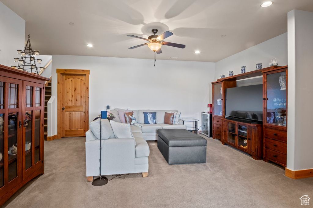 Living area featuring carpet flooring, a ceiling fan, stairway, and recessed lighting