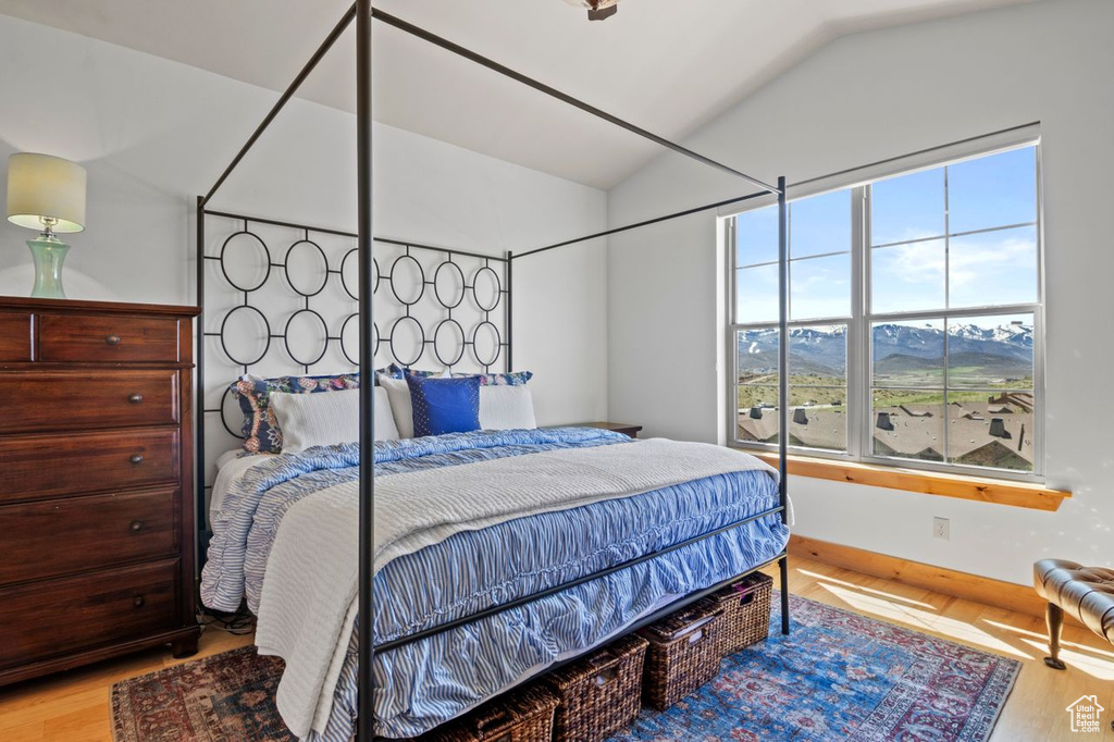 Bedroom featuring lofted ceiling, wood finished floors, and baseboards