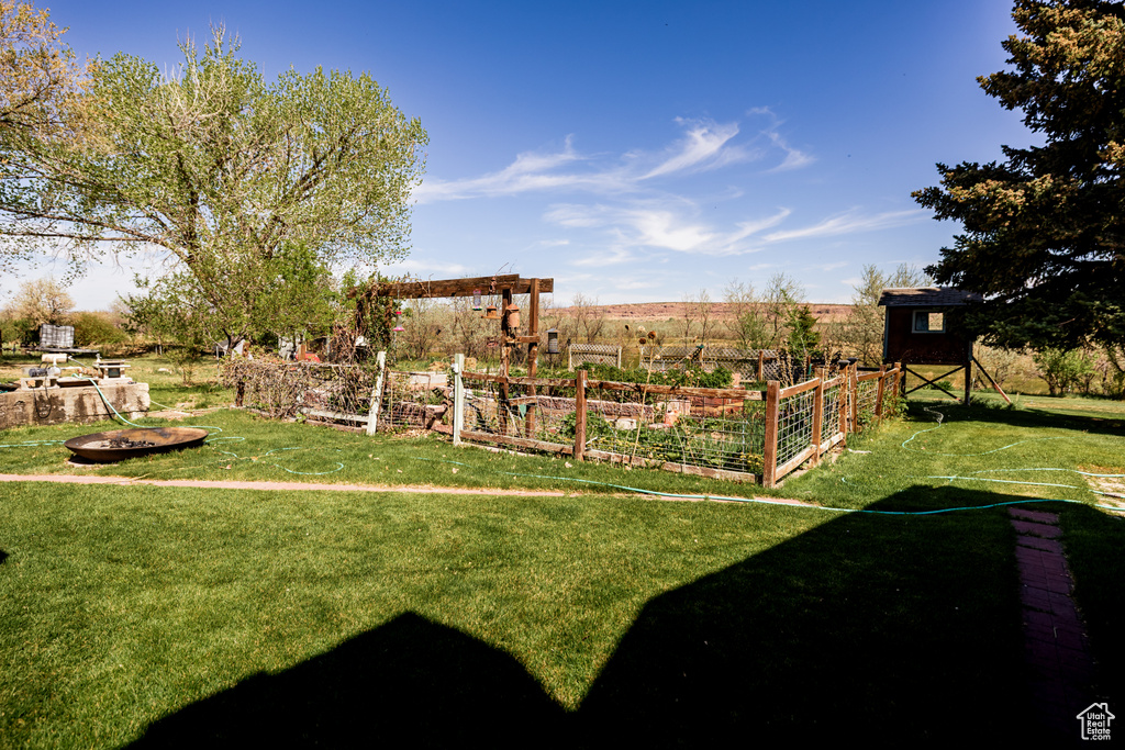 View of grassy yard with a vegetable garden and an outbuilding