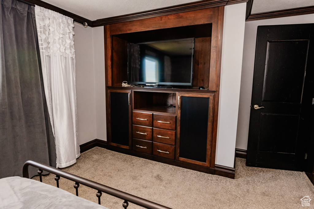 Bedroom featuring carpet flooring, baseboards, and crown molding