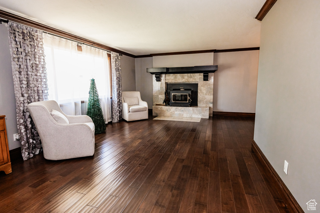 Living room featuring wood finished floors, crown molding, and baseboards