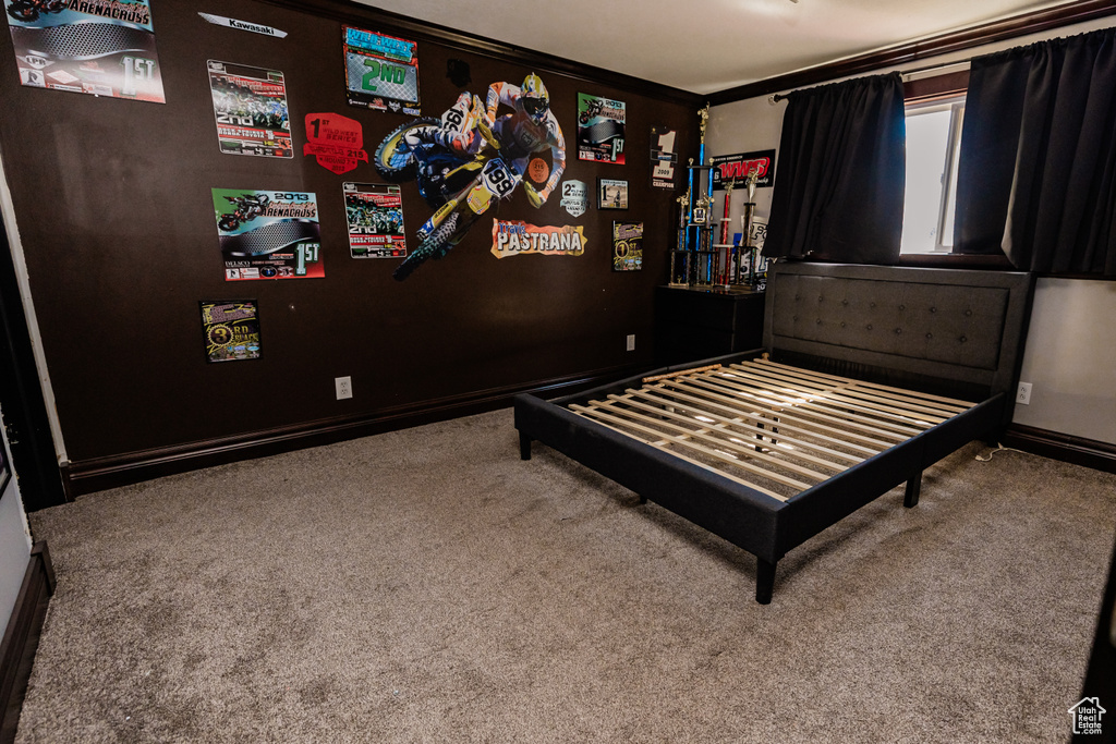 Carpeted bedroom featuring crown molding and baseboards