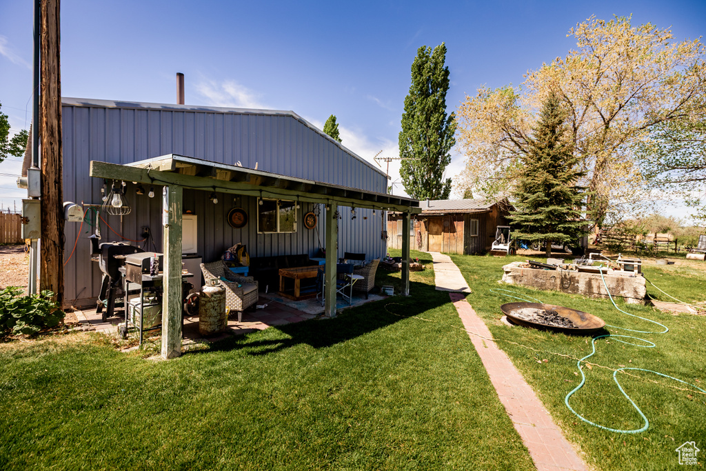 Back of house featuring an outdoor living space, a lawn, and a patio