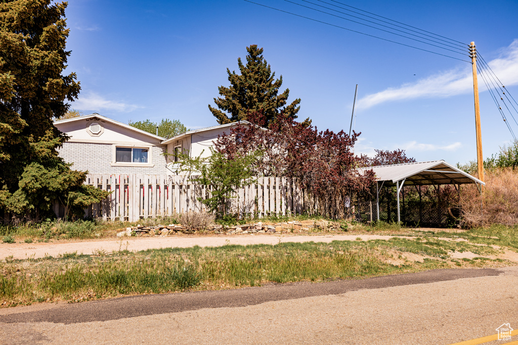 View of yard with a detached carport and fence
