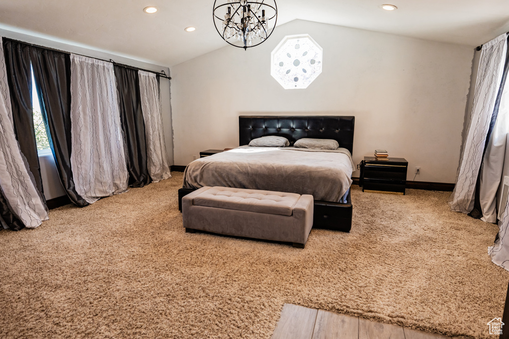 Carpeted bedroom featuring lofted ceiling, recessed lighting, a chandelier, and baseboards
