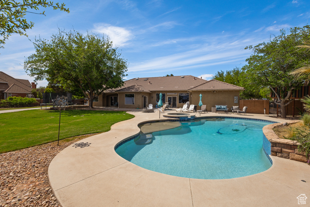 View of pool with a patio, a pool with connected hot tub, and a trampoline