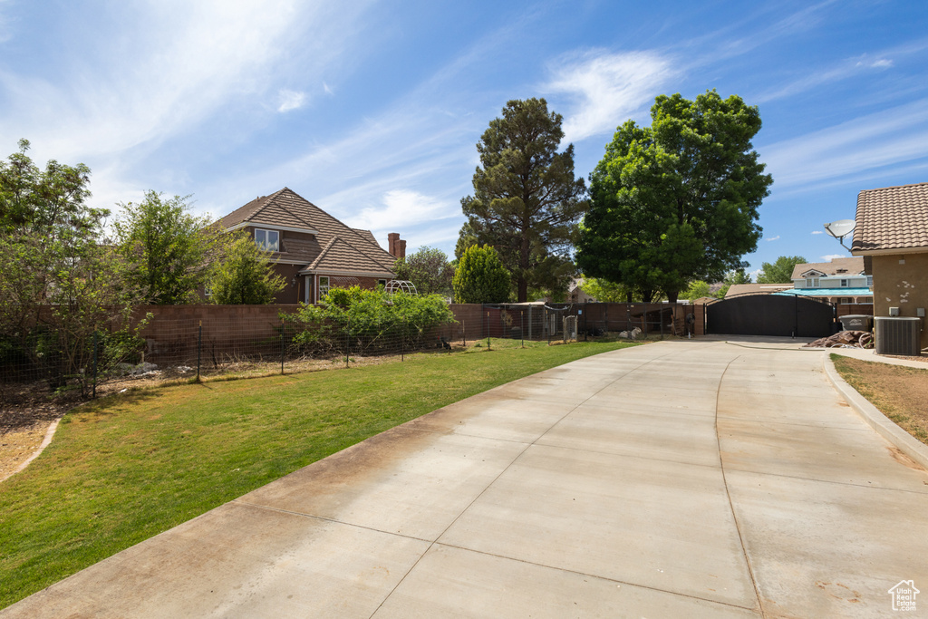 View of yard featuring cooling unit and concrete driveway