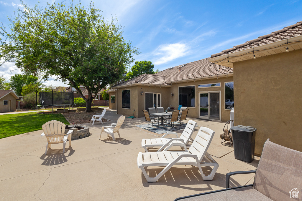 View of patio / terrace featuring a trampoline, an outdoor fire pit, and outdoor dining space