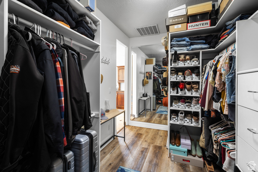 Walk in closet with wood finished floors