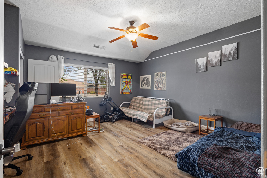 Office space with wood finished floors, a ceiling fan, lofted ceiling, and a textured ceiling