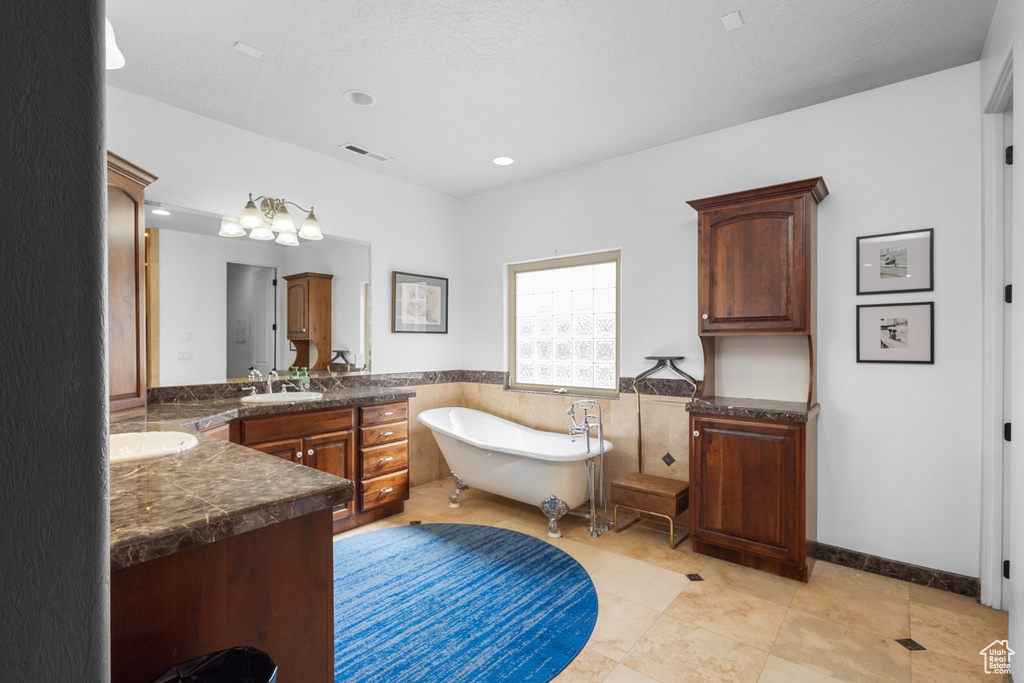 Bathroom with vanity, a soaking tub, a wainscoted wall, recessed lighting, and tile walls