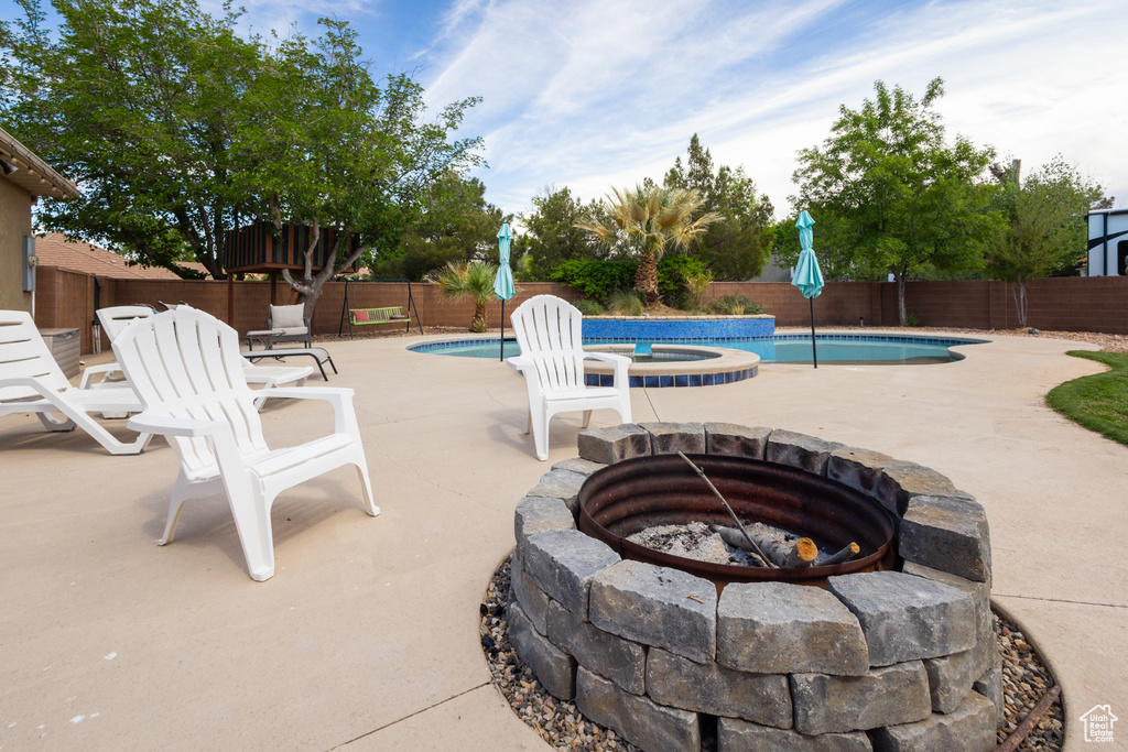 View of swimming pool with an outdoor fire pit, a fenced backyard, and a patio