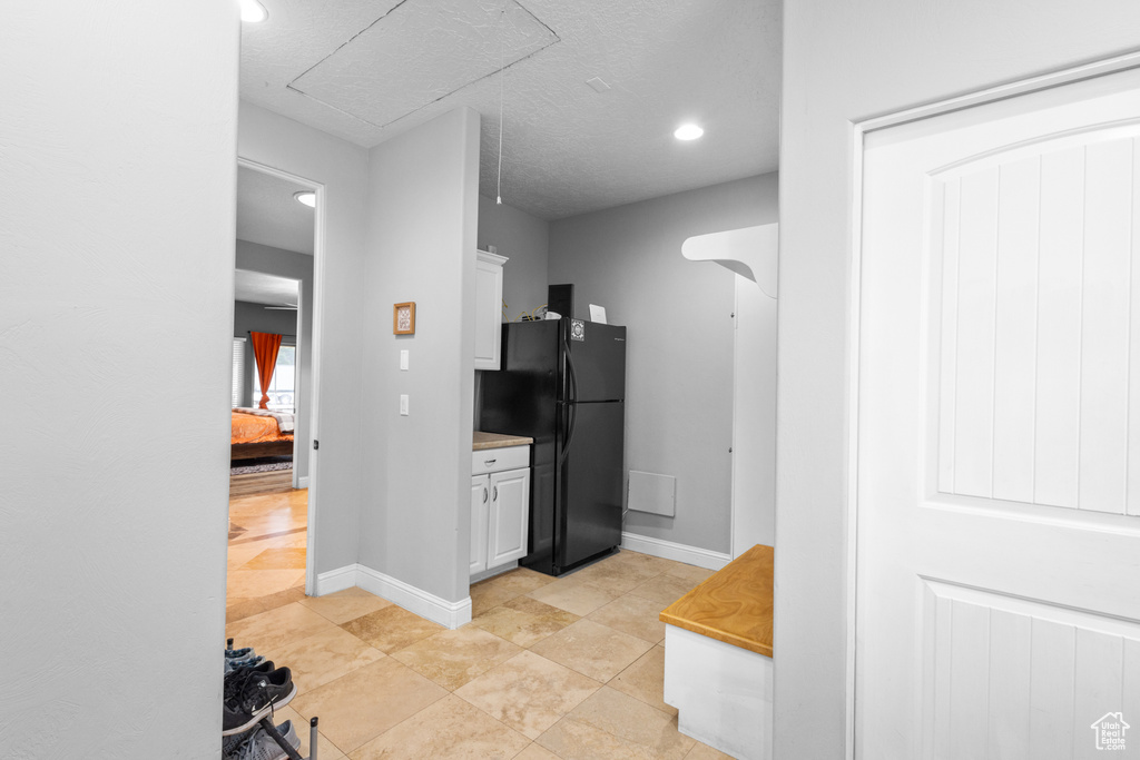 Kitchen featuring freestanding refrigerator, white cabinetry, recessed lighting, and baseboards