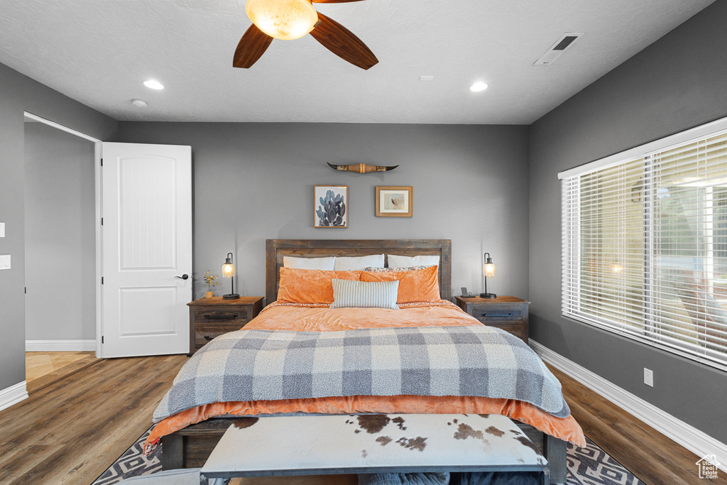 Bedroom with baseboards, wood finished floors, multiple windows, recessed lighting, and a ceiling fan